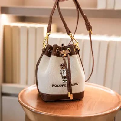 کیف وارداتی تدی گلدوزی جنس کنف بند چرمی قهوه‌ای و کرمی