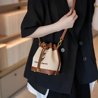 کیف وارداتی تدی گلدوزی جنس کنف بند چرمی قهوه‌ای و کرمی