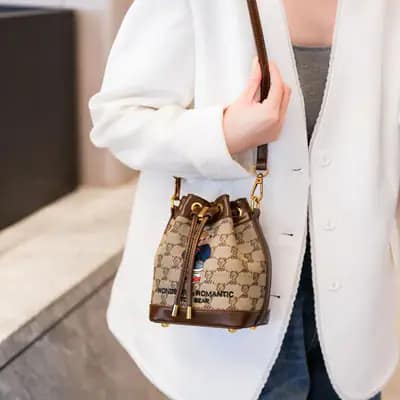کیف وارداتی تدی گلدوزی جنس کنف بند چرمی قهوه‌ای و کرمی