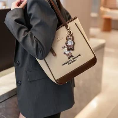 کیف وارداتی تدی گلدوزی جنس کنف بند چرمی قهوه‌ای و کرمی