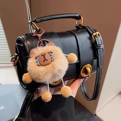 کیف مینی بگ استوانه ای زنانه وارداتی مدل رولین چرم واکسی مشکی با چارم عروسکی