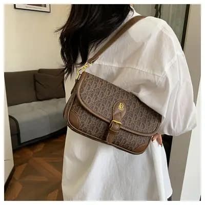 کیف زیربغلی وارداتی زنانه مدل دیور قهوه‌ای با بند چرمی و سگک فلزی طلایی روی دوش